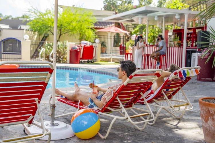 Man Poolside Relaxing next to beach ball