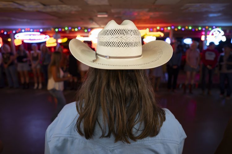 Woman wearing Cowboy Hat in a bar on dance floor