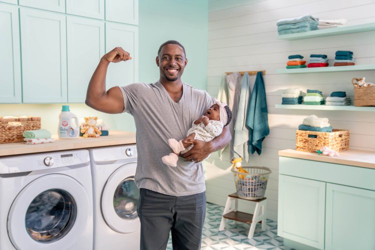 Man Holding Baby in Laundry Room