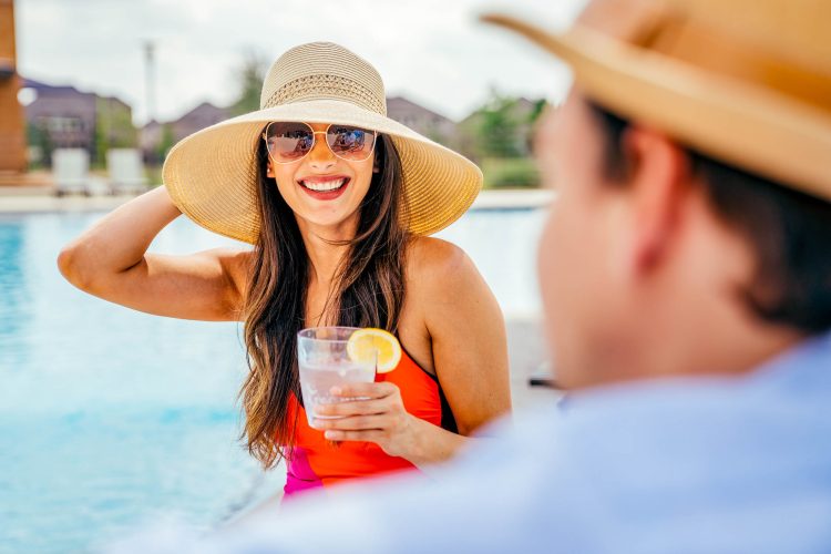 Woman with cocktail by pool