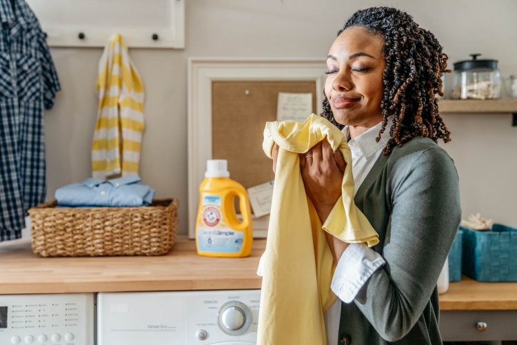 woman smelling freshly washed shirt