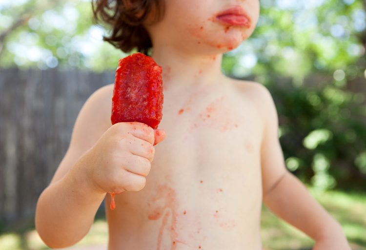 boy eating popsicle backyard