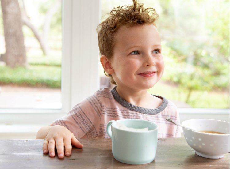 boy having breakfast while smiling