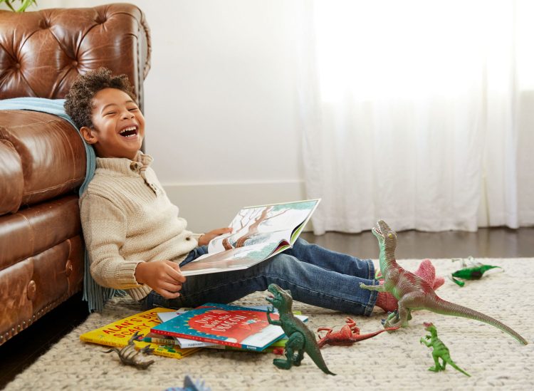 boy reading laughing dinosaurs