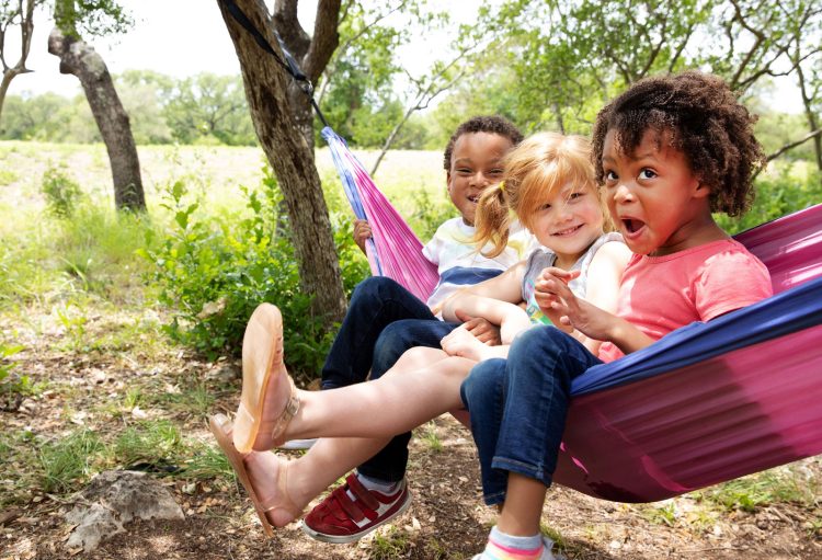 kids in hammock laughing under the trees