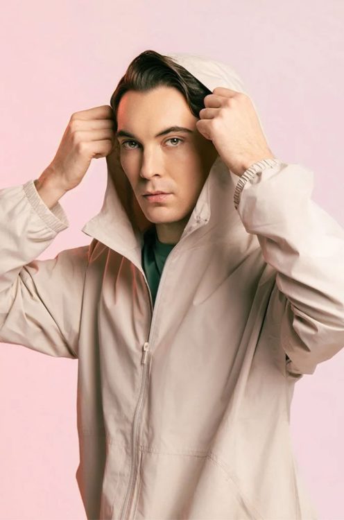 man holding hooded jacket over his head