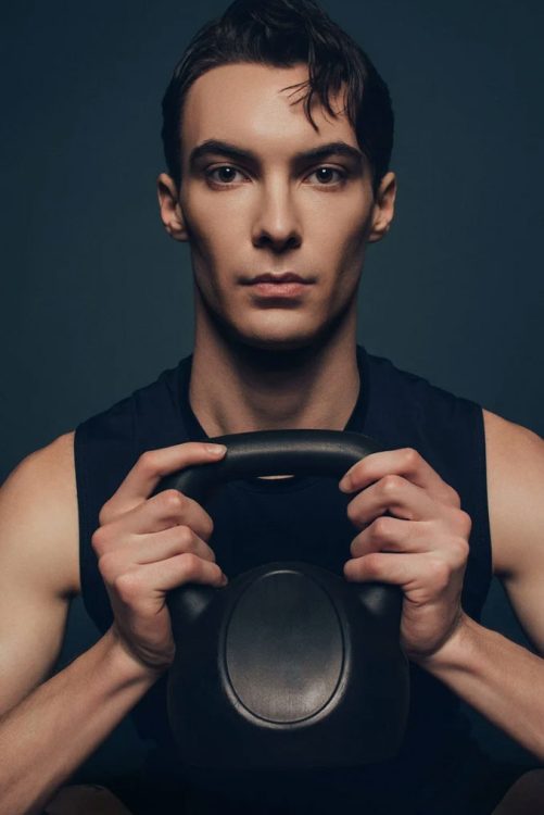 man holding kettlebell looking at camera