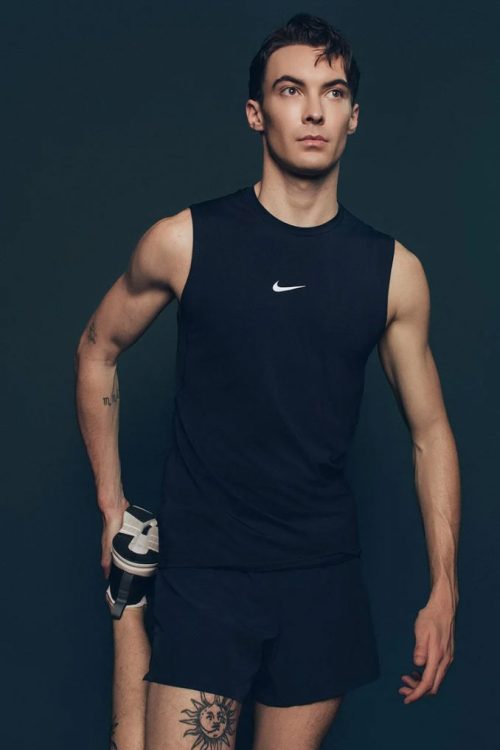 man stretching leg wearing nike shirt
