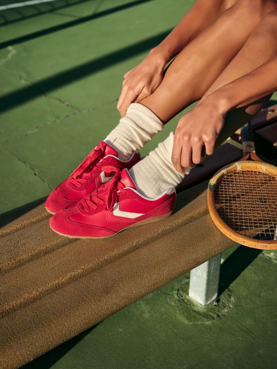 woman in red tennis shoes on bench